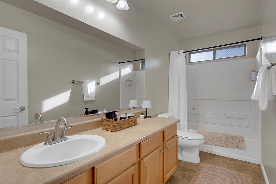 Sunlit and serene, this bathroom offers a relaxing soaking tub, soft bath rugs, and a clean, airy feel.