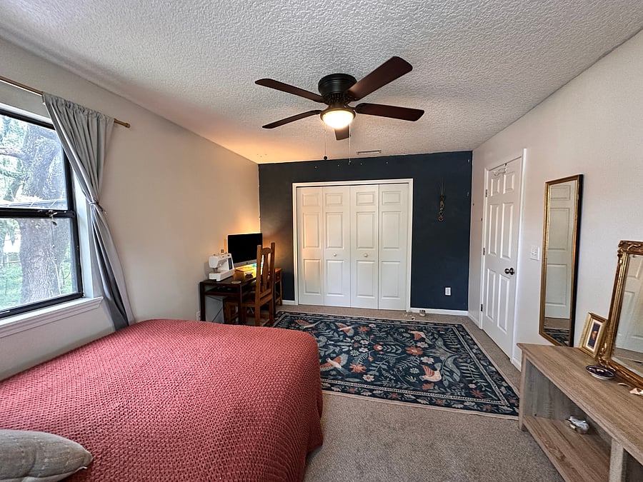 Bedroom includes large, empty closet with coat handers & dedicated workspace with Apple iMac