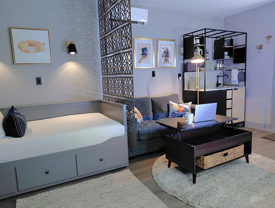 Living & Work Zone - A plush, comfortable sofa featuring convenient armrest side pockets and built-in USB-A and Type-C charging ports. The lift-top coffee table converts seamlessly into a desk for remote work or a dining table over a luxe area rug.