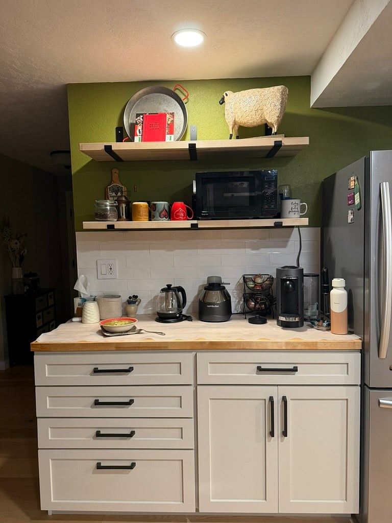 Beverage bar with Nespresso machine, microwave, and blender/food processor. Cabinet has pull-out shelves.