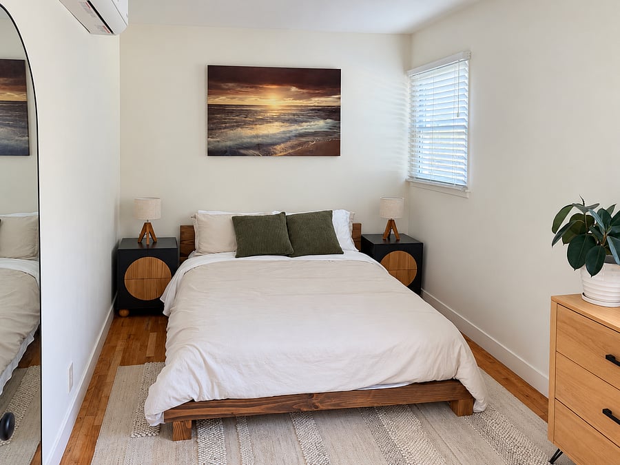 Rest comfortably in a serene primary bedroom with queen-size bed, cozy bedding, bedside lamps, dresser, and individual mini-split climate control.
