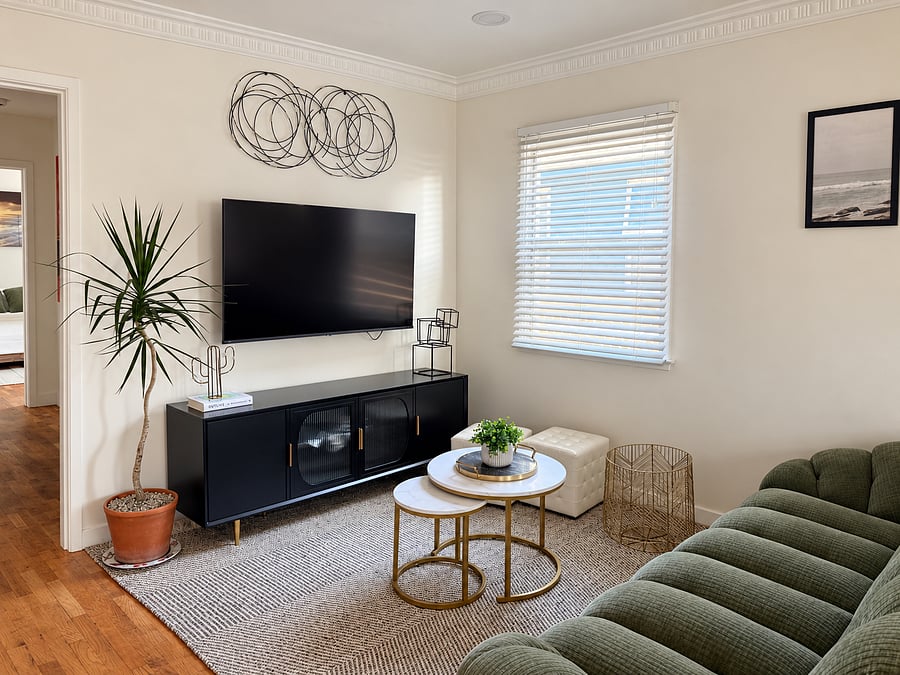 Enjoy movie nights with a large wall-mounted TV, sleek media console, comfortable seating, and mini-split climate control.