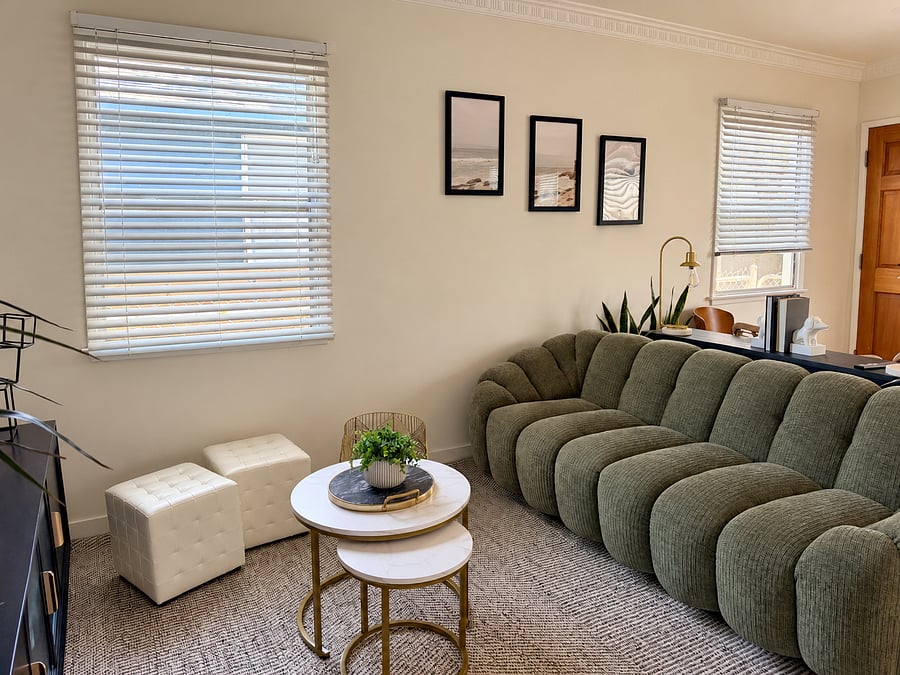 Relax on the spacious olive-green sofa with cozy area rug, nesting coffee tables, and natural light. An inviting spot to unwind after work.