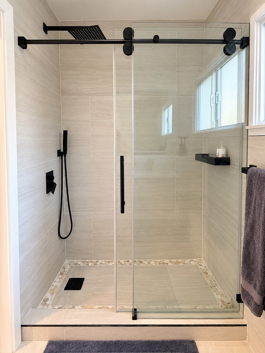 Spa-inspired walk-in shower featuring a rainfall showerhead, handheld sprayer, frameless glass enclosure, and elegant floor-to-ceiling tile.