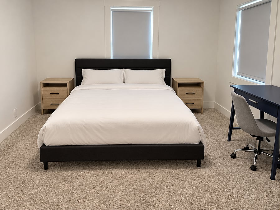 Spacious primary bedroom with a king-size bed, fresh linens, bedside tables, dedicated workspace with desk and chair, and a large walk-in closet with ample storage and hangers.