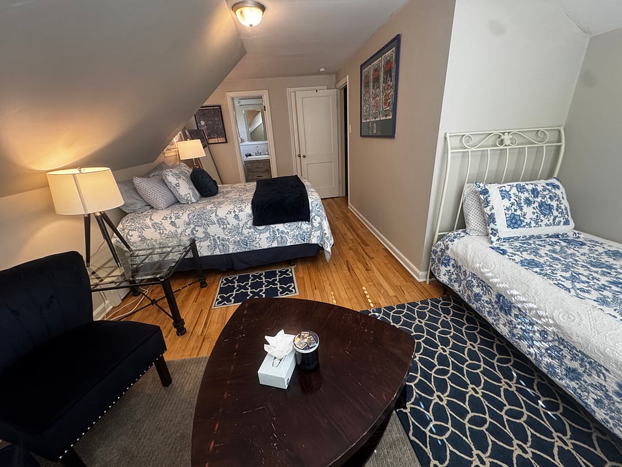 A charming twin bed with a beautiful white wrought-iron headboard and coordinating blue and white bedding offers an additional cozy sleeping space. Perfect for families, friends, or guests who prefer their own bed.