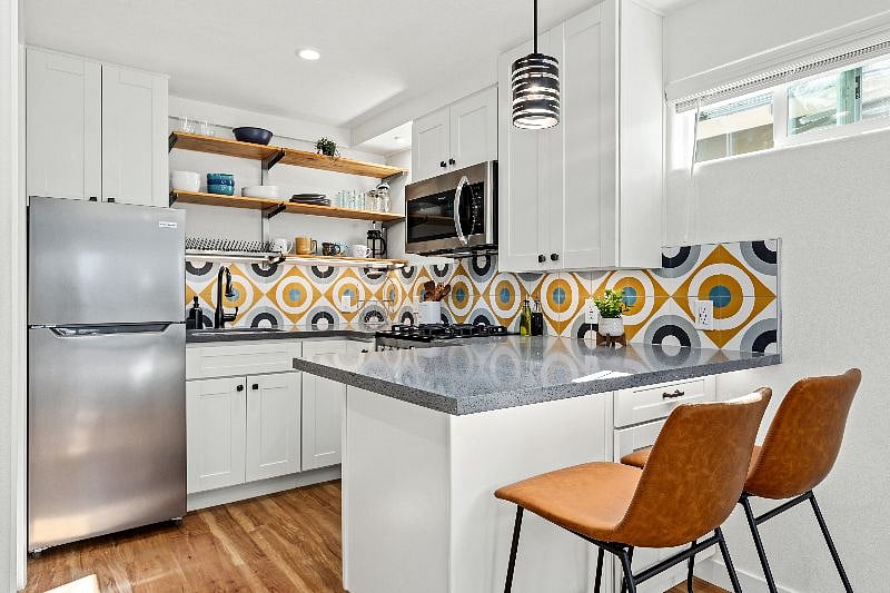 Full kitchen with stainless steel appliances and open shelving