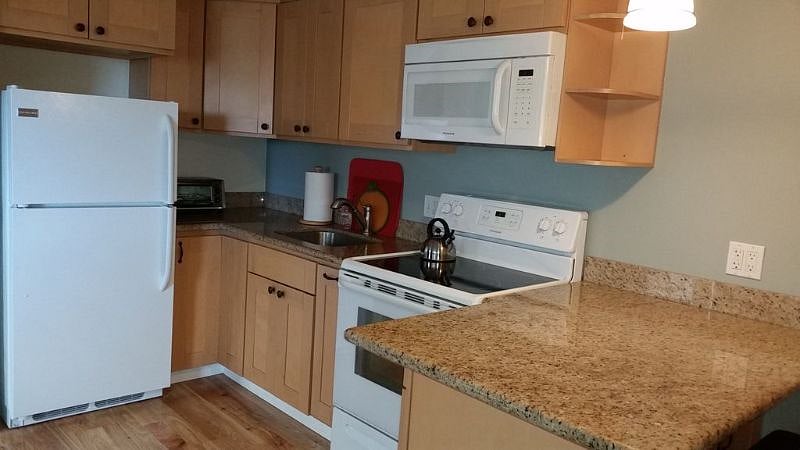 Kitchen with granite counters, full size refrigerator and stove