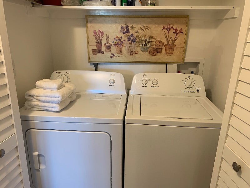 Full sized washer and dryer in the laundry closet. Long shelf above with detergents and cleaners.