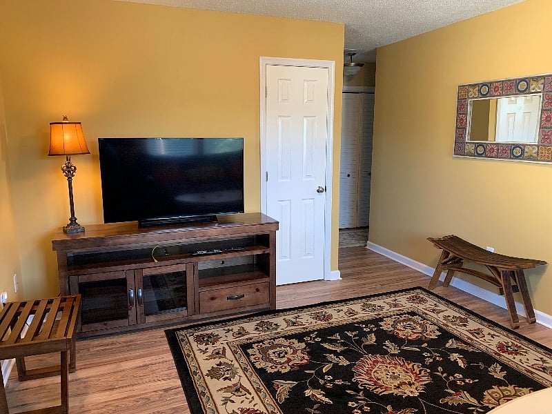 Large flat screen TV and wine barrel stool.