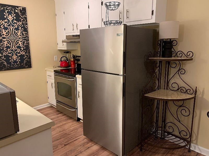 Modern stainless appliances including full sized fridge, range, dishwasher and microwave.