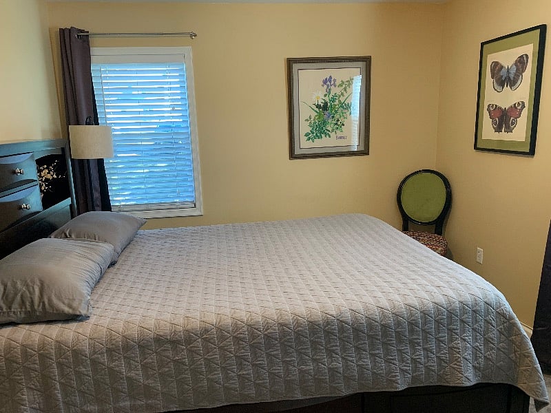 Bright bedroom with two windows and blackout curtains for good sleep.