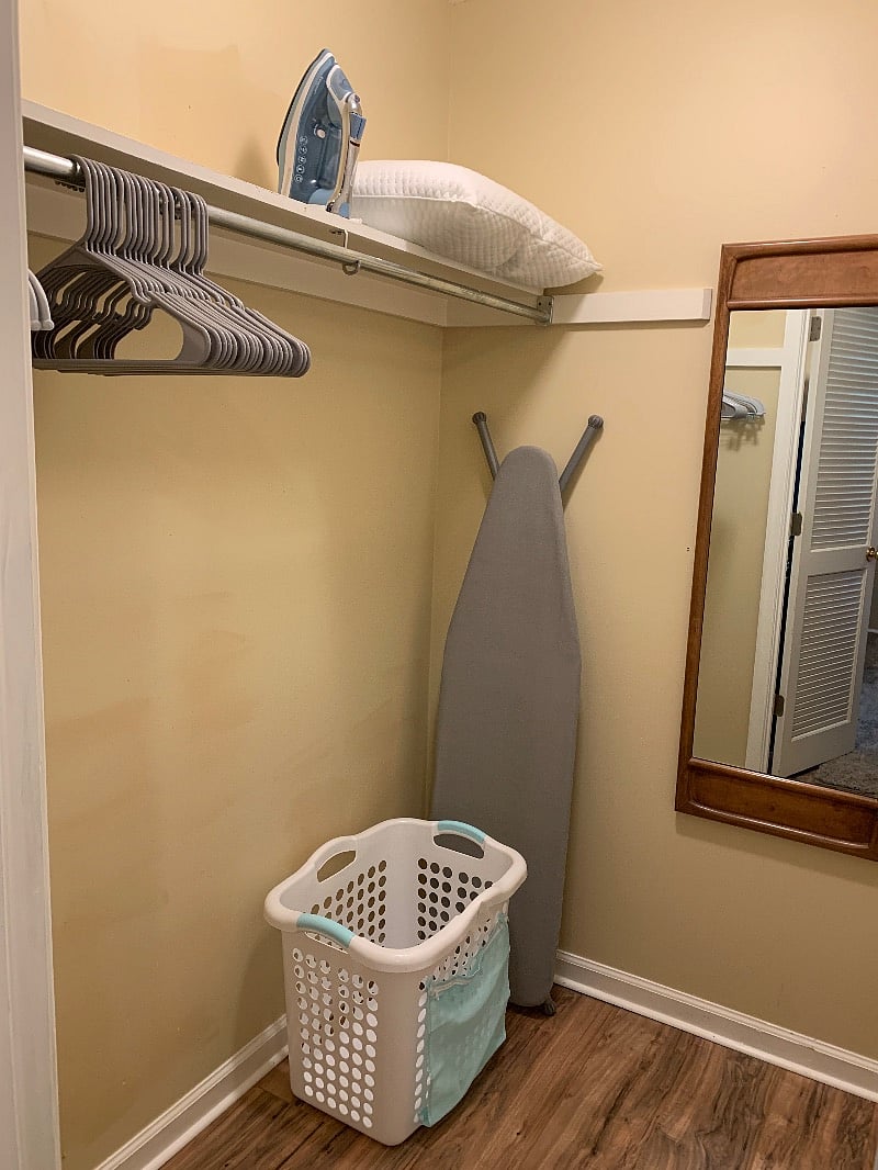 Walk in closet with shelving, hangers, full length mirror.