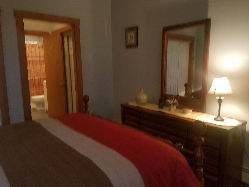 bedroom showing bureau and bathroom view