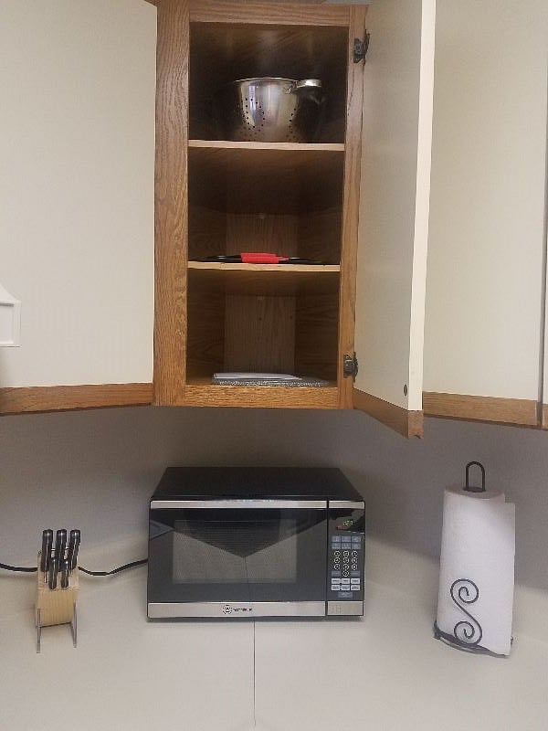 fully stocked cabinets in roomy kitchen