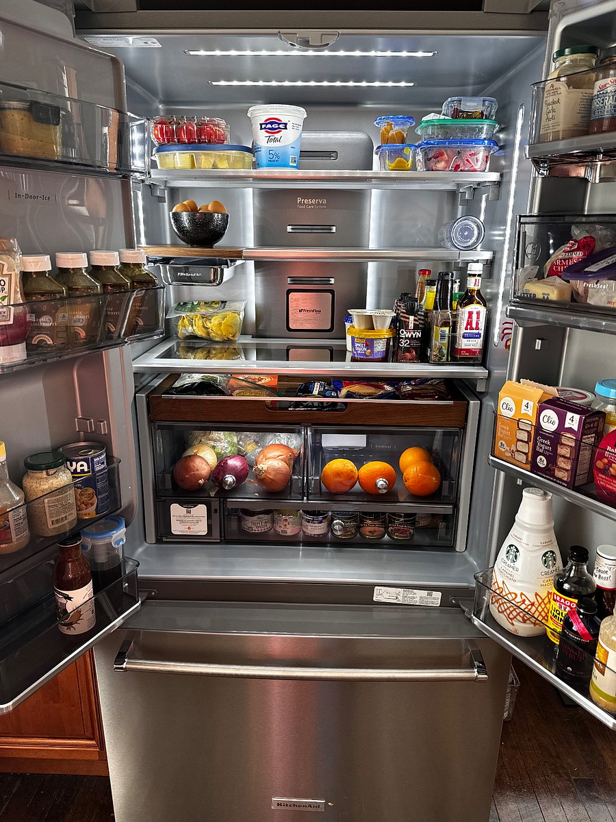 New large KitchenAid refrigerator with wood trim interior. You will get half the fridge.