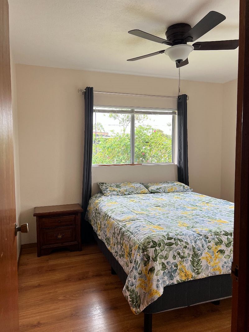 Second bedroom with new queen sized bed, large closet, dresser, nightstand with lamp and chair. There is also a ceiling fan/light, with new room darkening blinds and blackout drapes