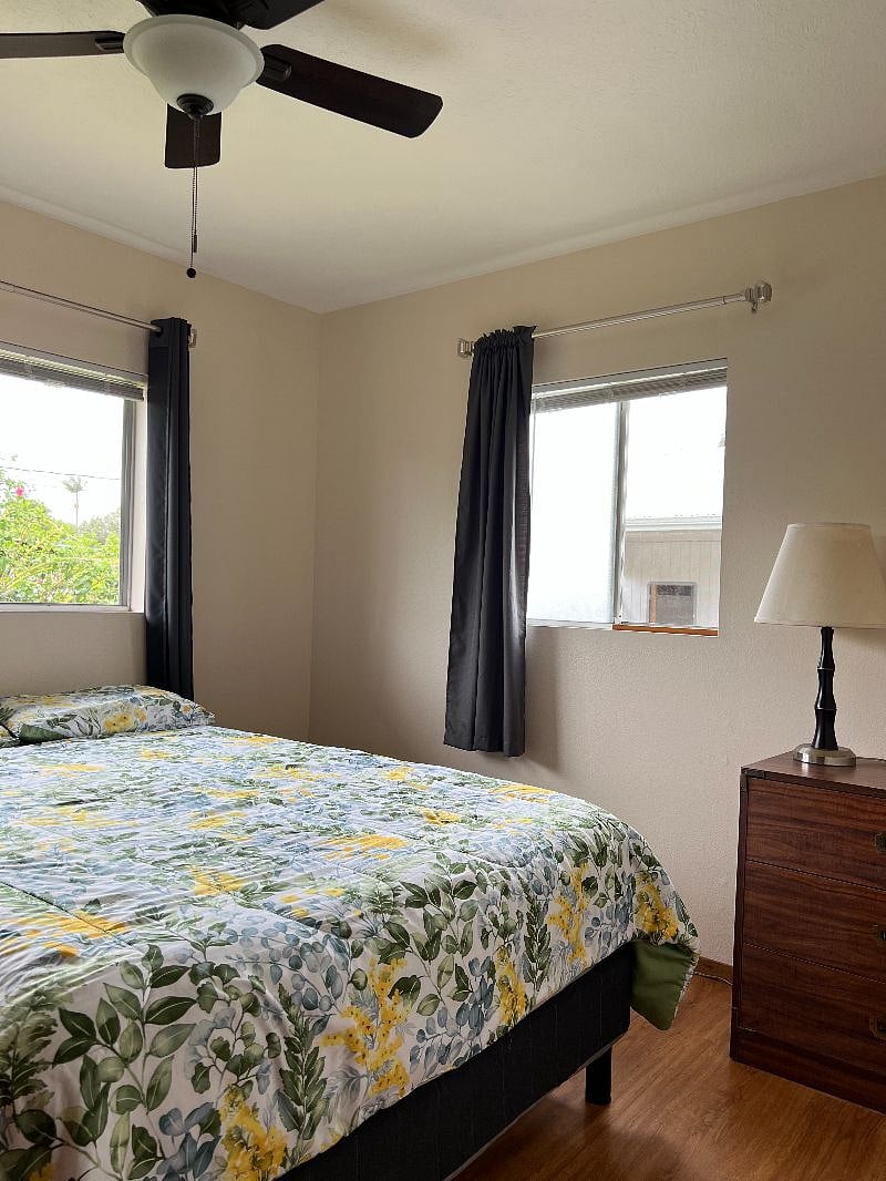 Secpm bedroom with new queen sized mattress, large dresser, nightstand with lamp, ceiling fan/light.