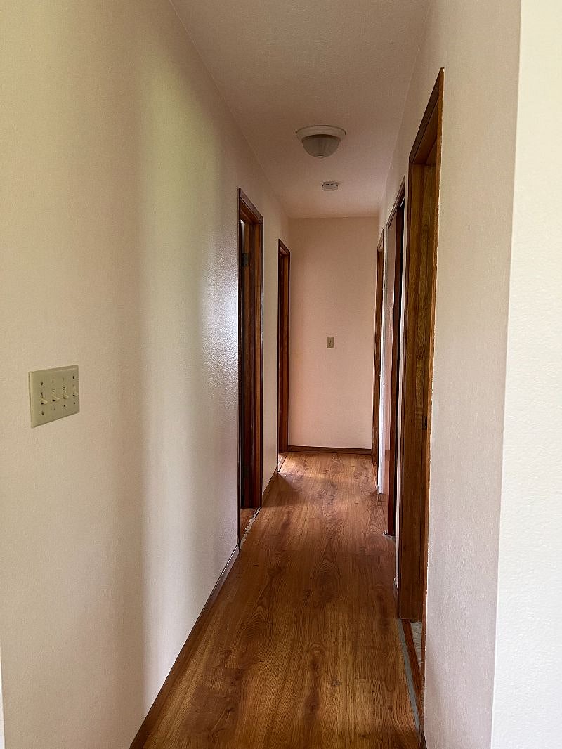 Hallway from living room to main bathroom and three bedrooms.