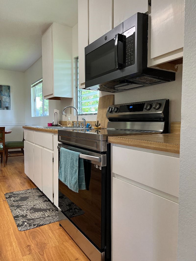 Full kitchen with new electric range and new microwave with fan and light.
