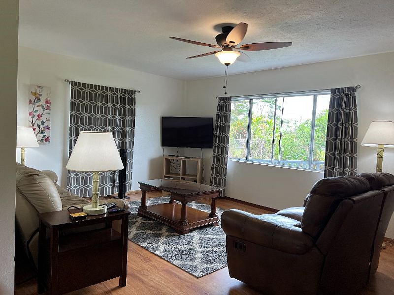 Living room with leather couch and leather love seat, smart TV, lamps, paintings, ceiling fan/light,new room darkening blinds and blackout drapes