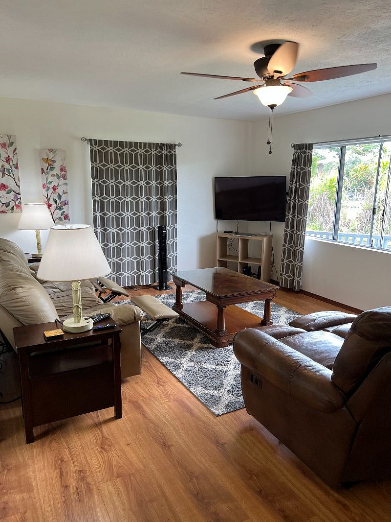 Living room with leather couches, new lamps, new end tables and new coffee table.