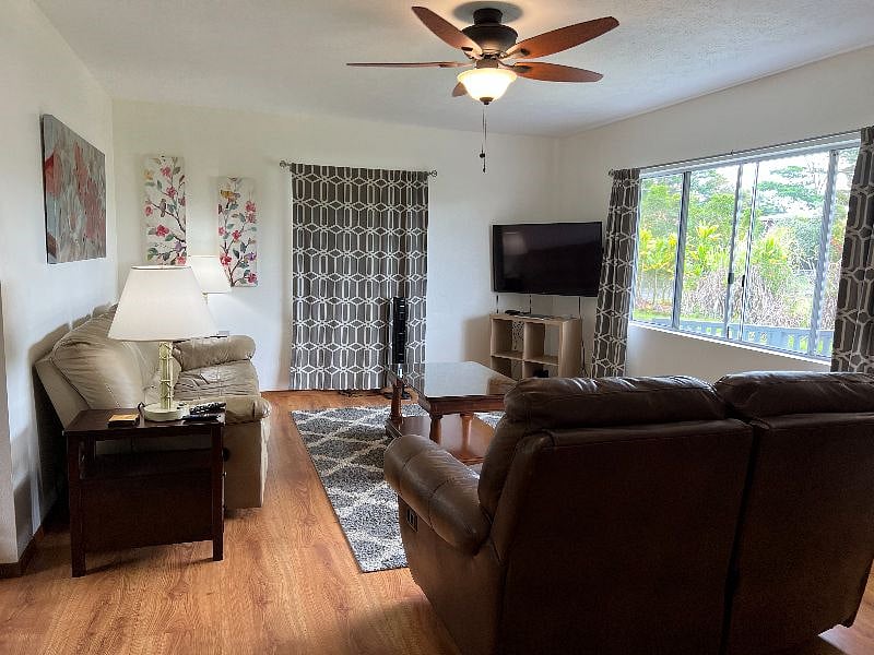 Living room with leather couch and loveseat, each with recliners on each end.