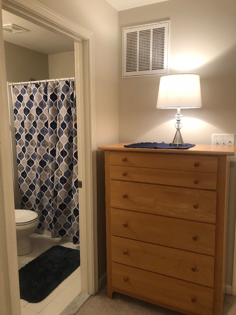 Bedroom has dresser, Smart TV, nightstand, and full length mirror.