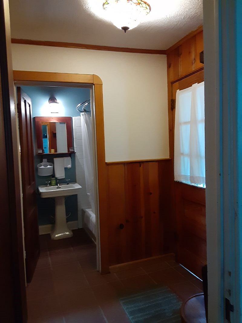 Cabin Room private bath - also shown is the private entrance. There is also a chair, coat hooks and a high shelf.