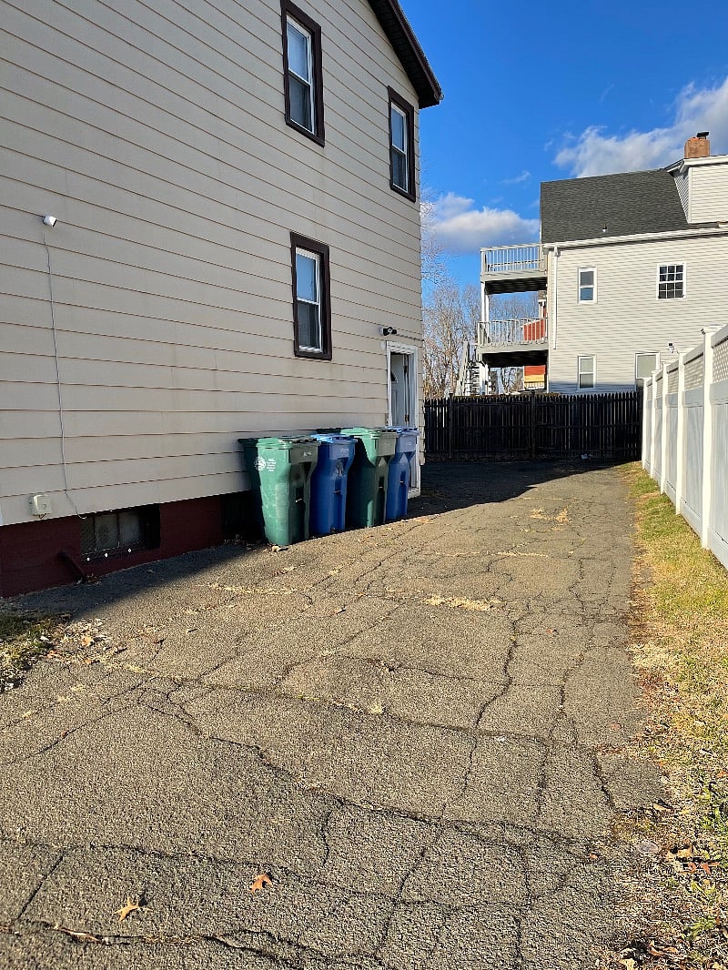 Driveway view of property including the side/back door entrance into the house.