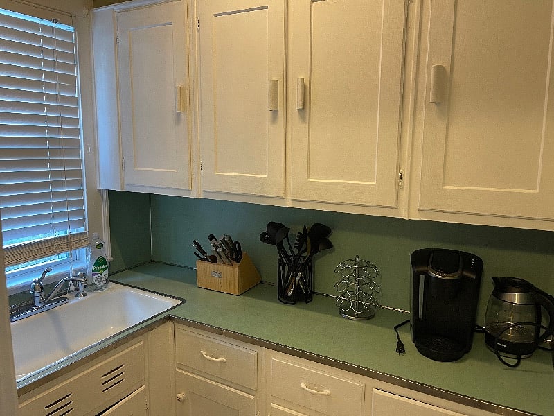 Kitchen nook where sink and additional storage is located. Keurig machine and electric kettle available for use. 