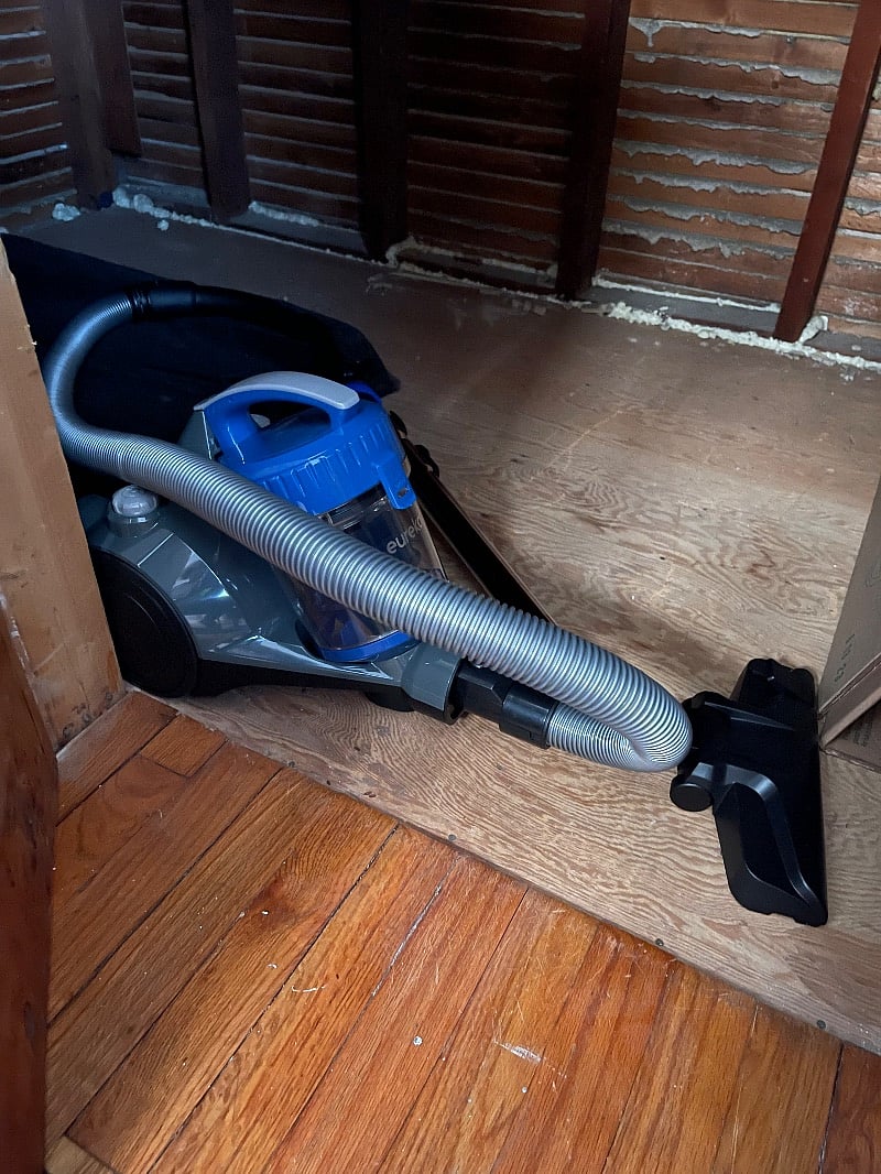 Corded canister vacuum stored in living room storage closet. 