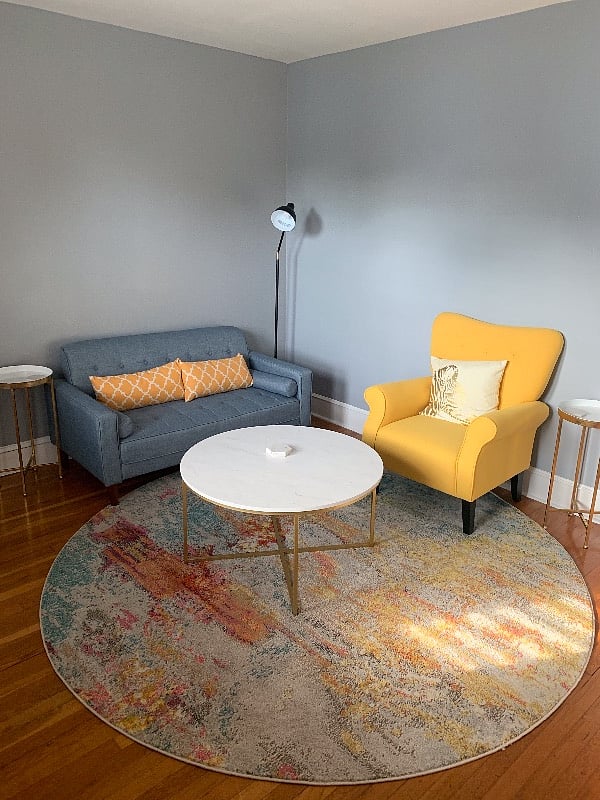 Living room with two seater sofa and single sofa chair.