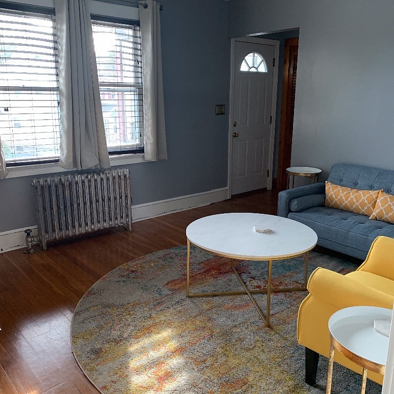 Living room with view of private porch entrance to the left, large closet and front door entrance.