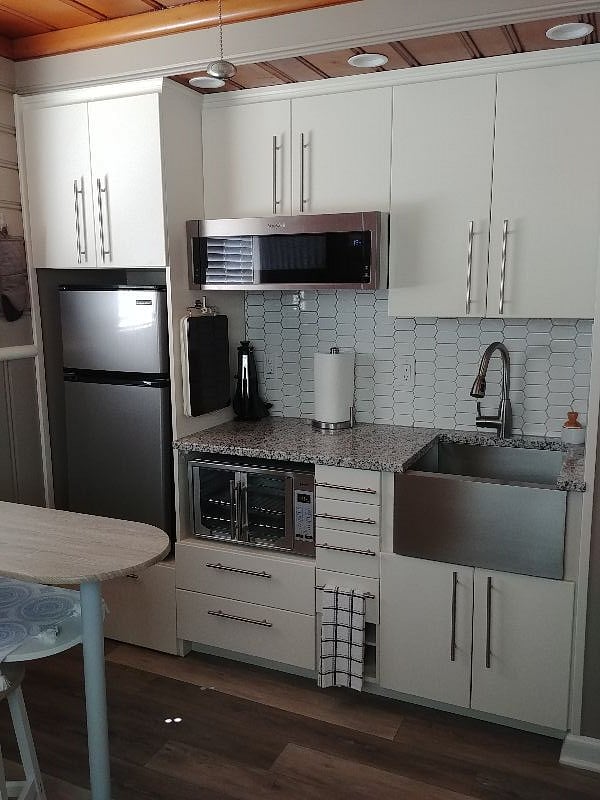 Tiny kitchen that combined with living area. Two burner induction range top is hangs on the side of the refrigerator cabinet.