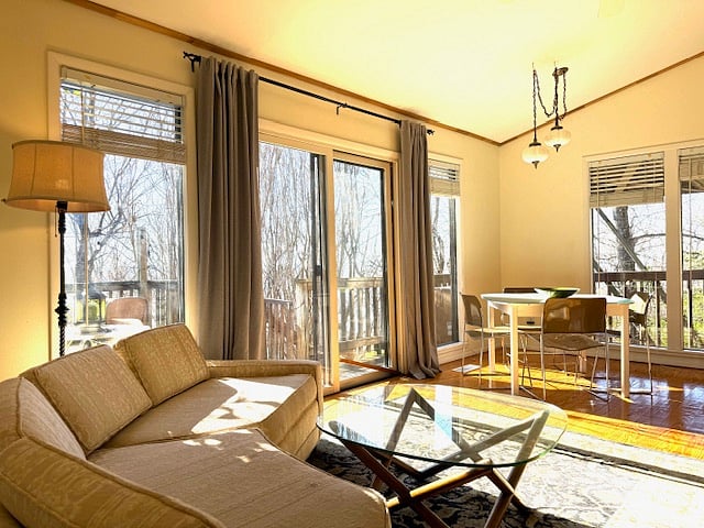 Dining area in open living and kitchen space. Sliding glass doors to south facing deck