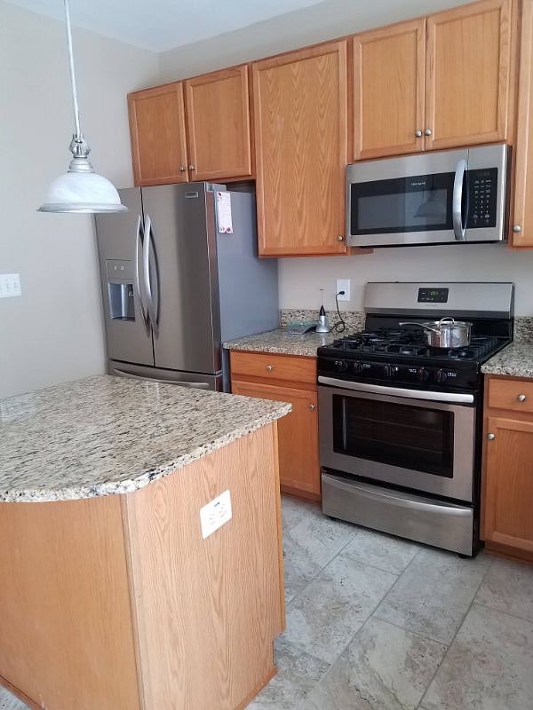 A kitchen with all the buzz words: granite, stainless, gas range, dishwasher, kitchen island...not to mention a balcony off the kitchen.  Score!!