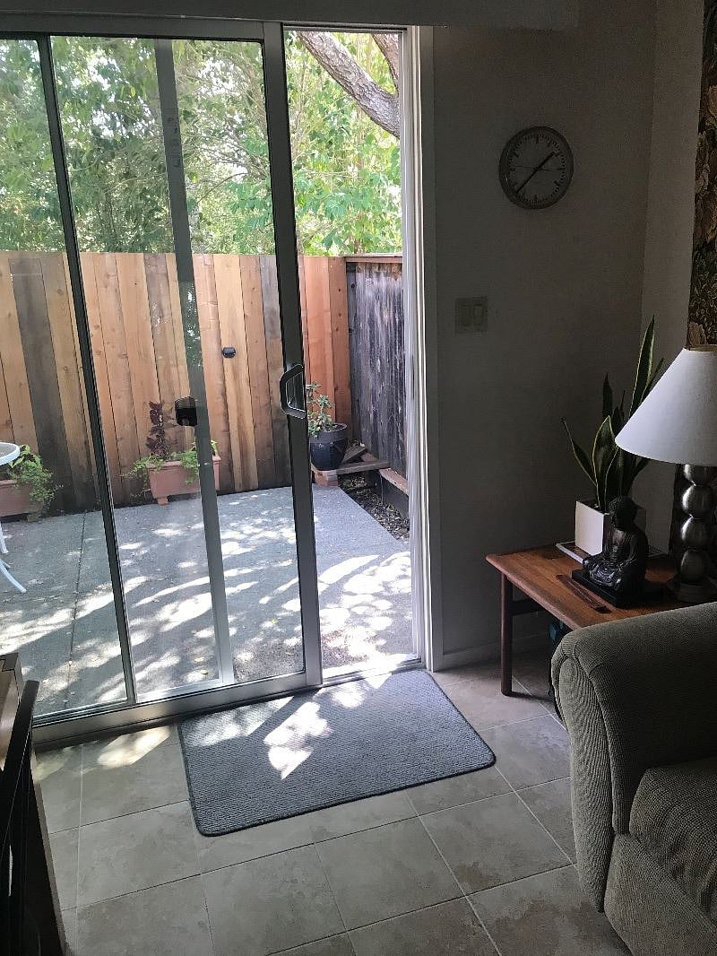 view toward patio and entryway from living/dining room. Gas grill on patio. 
