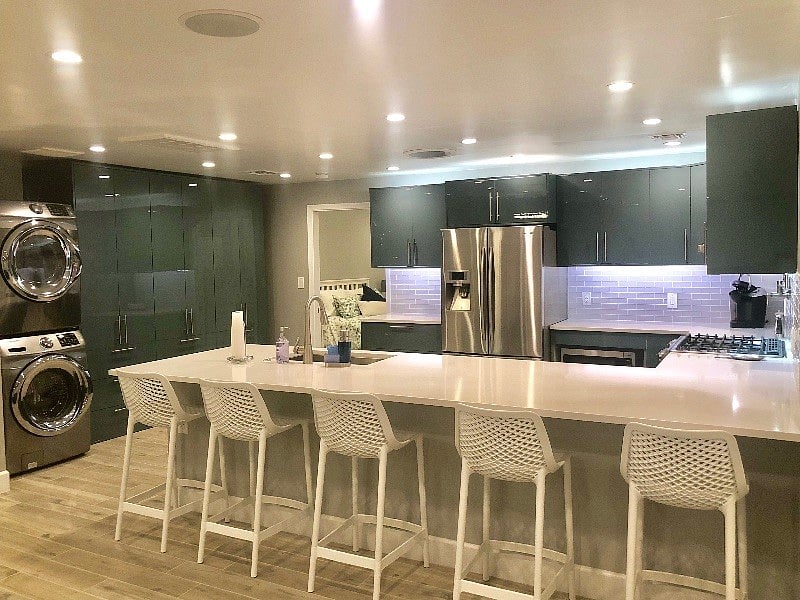 Full-sized front loading washer and dryer in unit. Above and below cabinet LED lighting. 