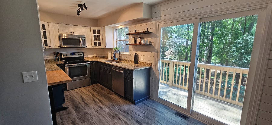 Kitchen opens up to the balcony overlooking the heavily wooded forest.