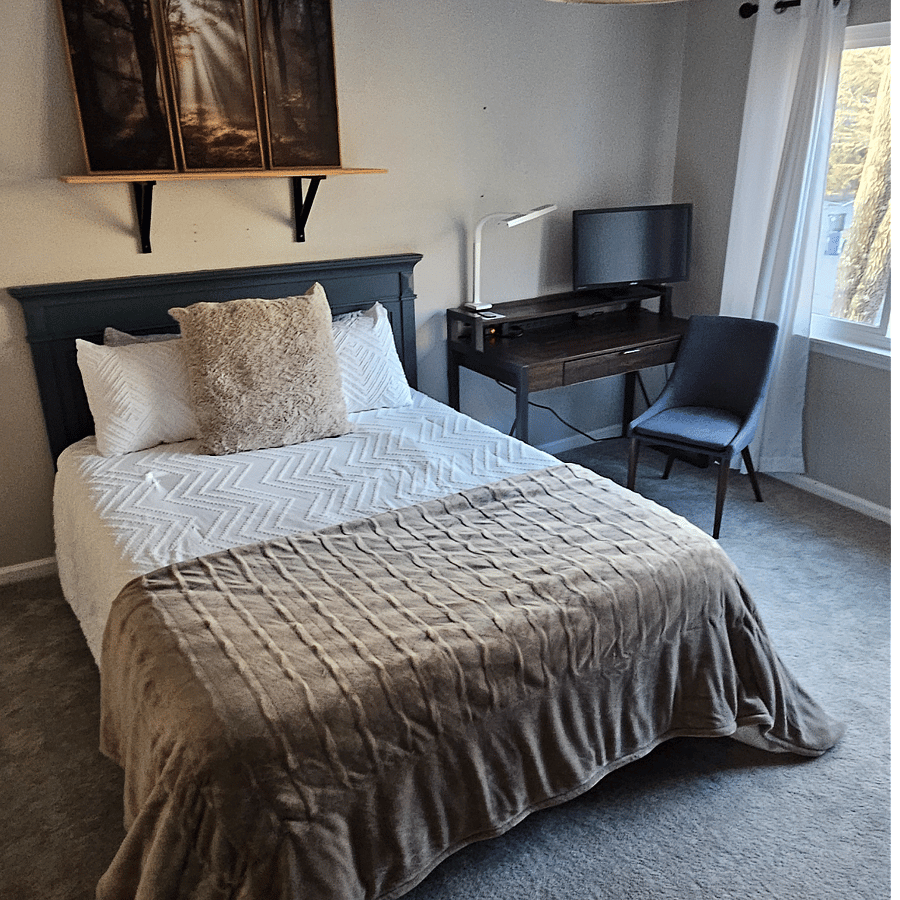 The secondary bedroom has a workstation with a mntior and HDMI cables.