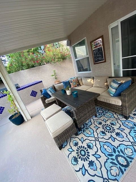 Covered patio with comfy outdoor seating and BBQ, Outdoor 50" Smart TV installed on the patio. Ambient twinkle lights on the patio and trees for the evenings. 