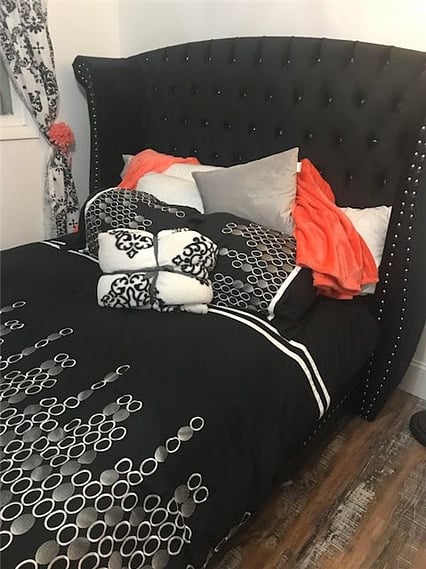 Tufted Upholstered bed with tons of soft throw blankets and extra pillows. Both feathered and non. 
