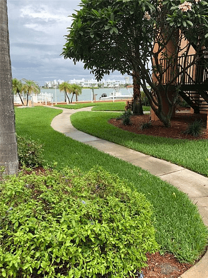 Sidewalk leads to the front door, just steps from the water.
