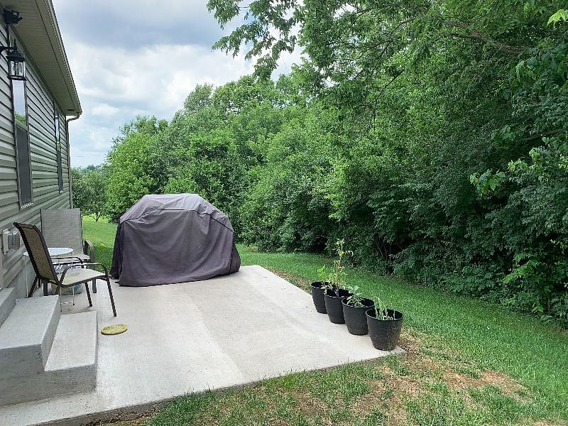 Backyard. There is a gas grill. It has been fenced in since these photos and there is a patio table with chairs.