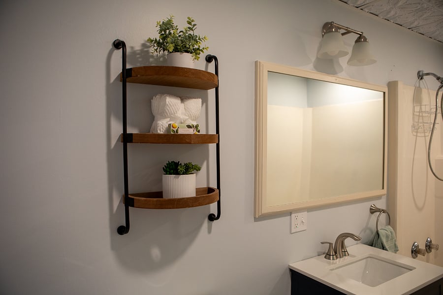 The bathroom has a shower/tub and a new vanity, toilet, flooring, mirror, lighting, paint and trim.