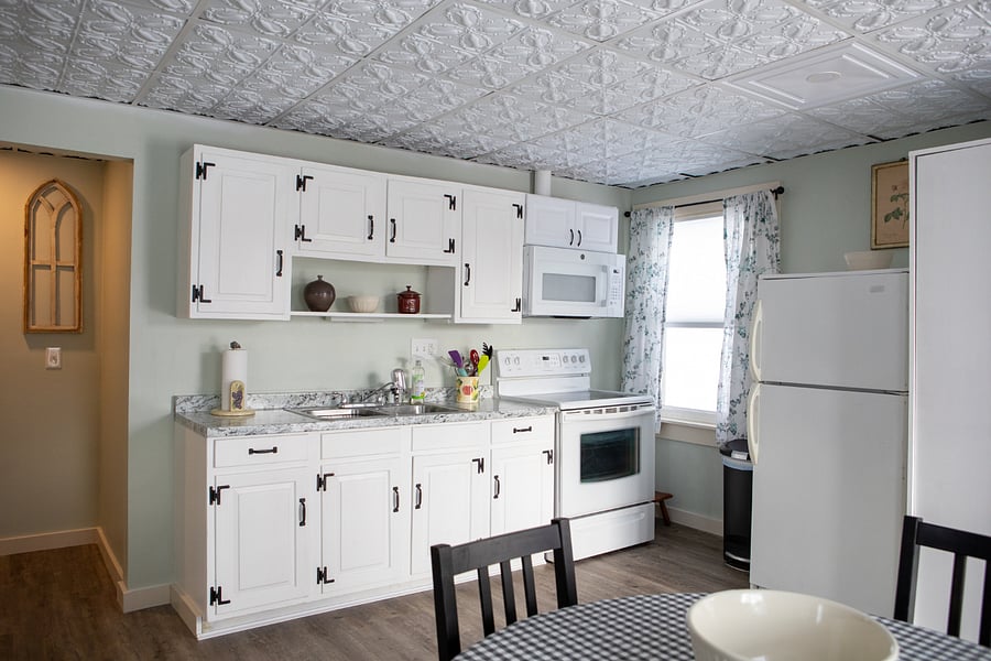 The kitchen is fully stocked with plates, silverware, pots, pans, glasses, a coffee maker, crock pot, blender, toaster, microwave, full-sized stove and refrigerator.