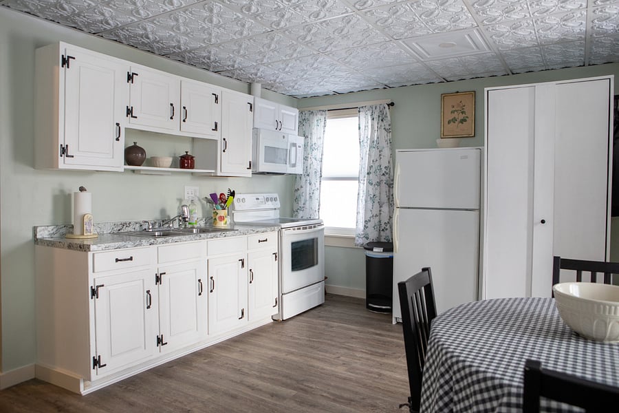 The kitchen is fully stocked with plates, silverware, pots, pans, glasses, a coffee maker, crock pot, blender, toaster, microwave, full-sized stove and refrigerator.