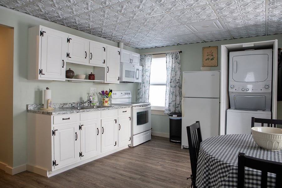 There is a washer dryer unit housed in a cabinet next to the fridge.