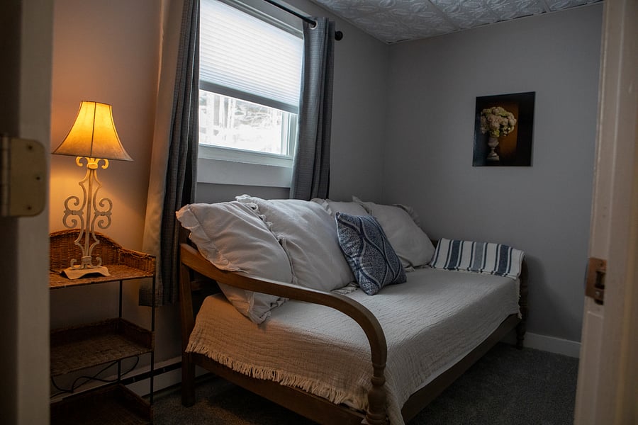 This is the small bedroom. It has a day bed, a night stand a closet and a window but is quite small.